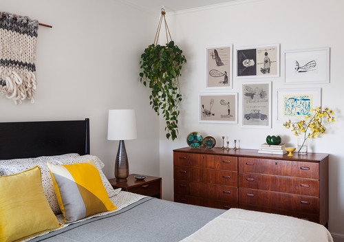 mid-century modern bedroom with a gallery wall and plant hanging