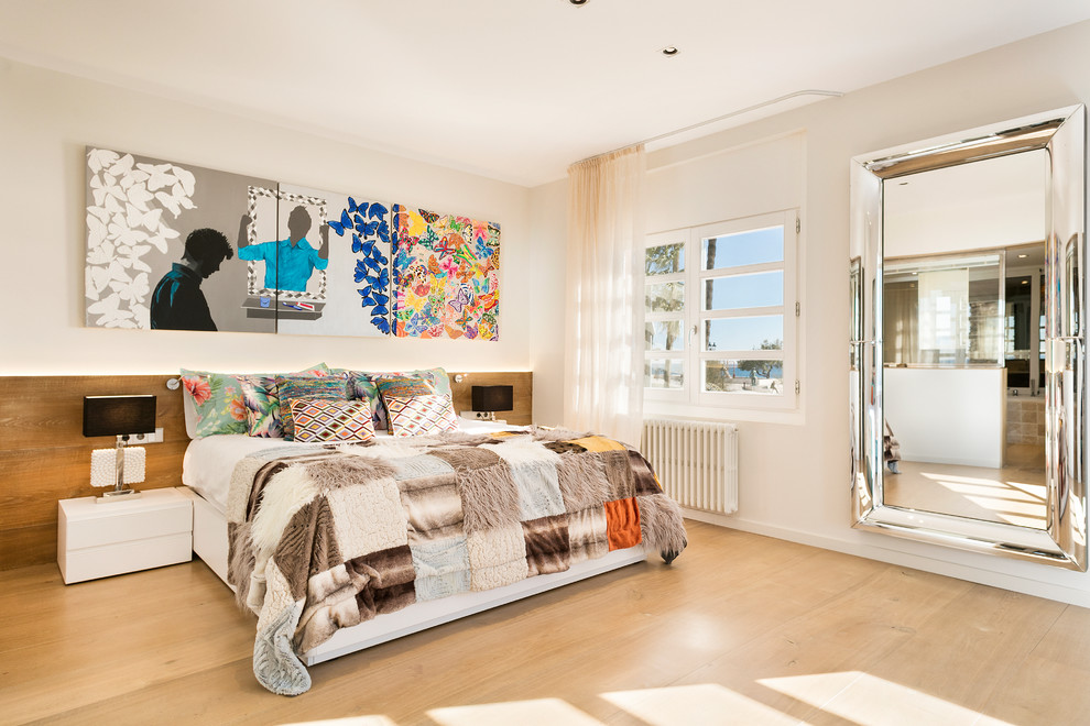 Diseño de dormitorio principal contemporáneo grande con paredes blancas, suelo de madera clara y suelo beige