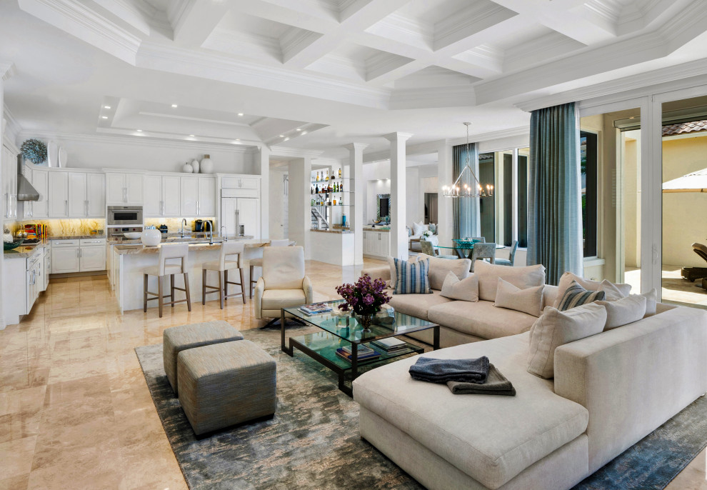 Expansive mediterranean open concept family room in Miami with a home bar, white walls, beige floor and coffered.