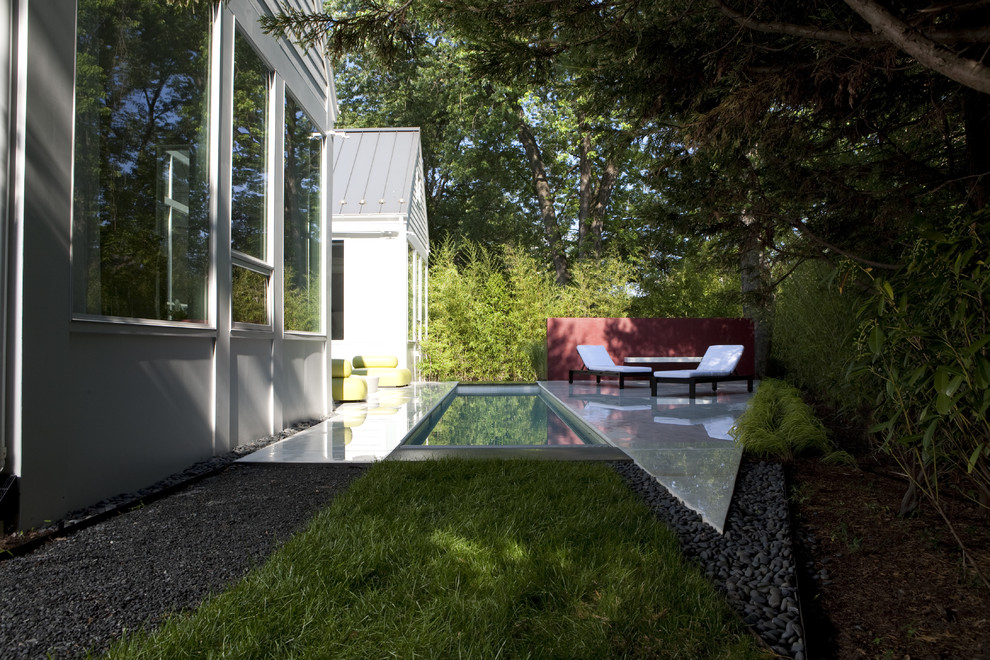 Inspiration for a mid-sized transitional backyard rectangular lap pool in DC Metro with natural stone pavers.