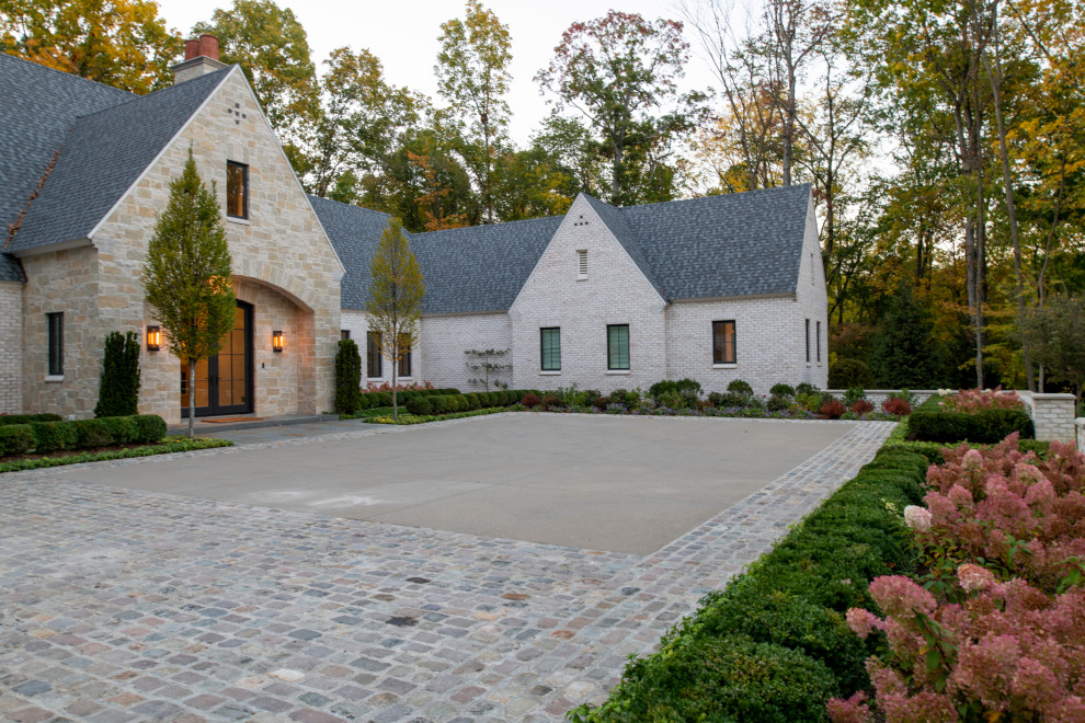 Пример оригинального дизайна: участок и сад среднего размера на переднем дворе в классическом стиле с перегородкой для приватности и покрытием из каменной брусчатки