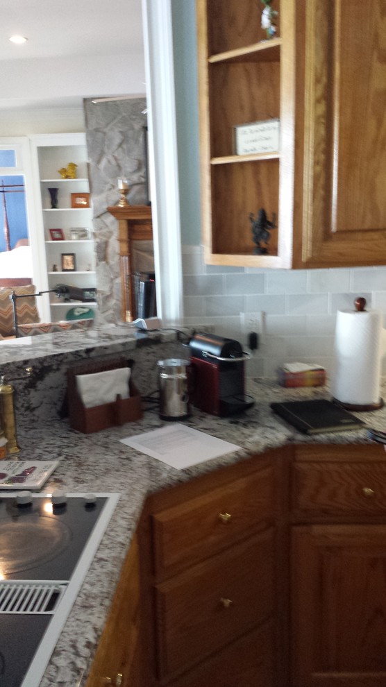 Example of a transitional kitchen design with shaker cabinets, white cabinets and an island