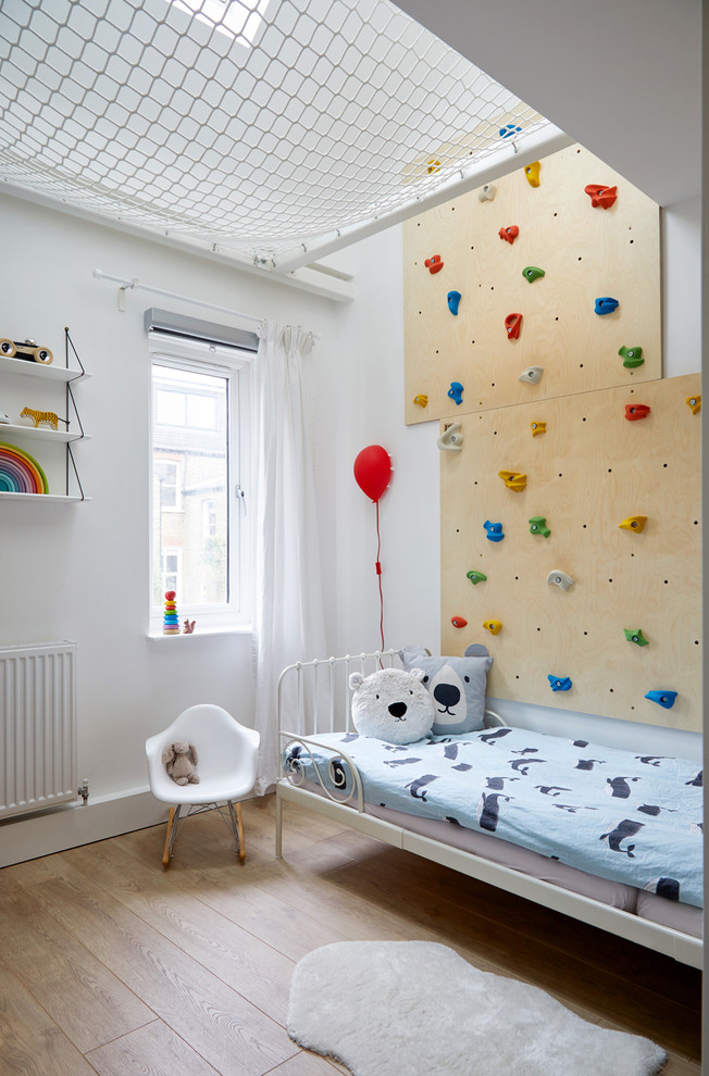 Small scandinavian kids' room in London with multi-coloured walls and light hardwood floors.