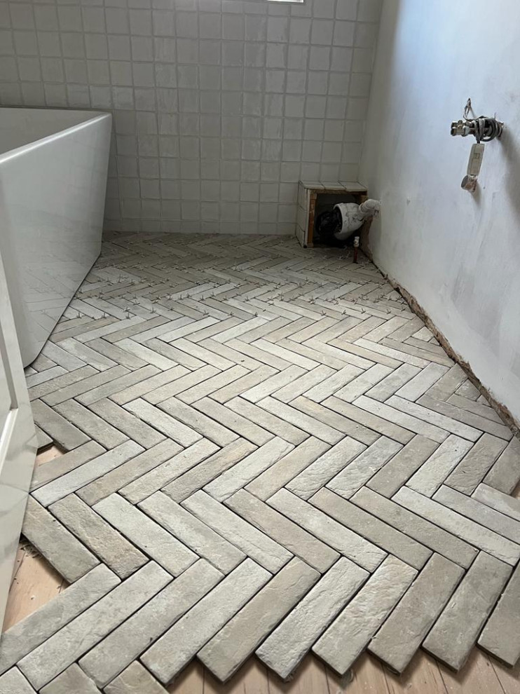 he herringbone, natural stone look to floor gives an illusion of width to the na