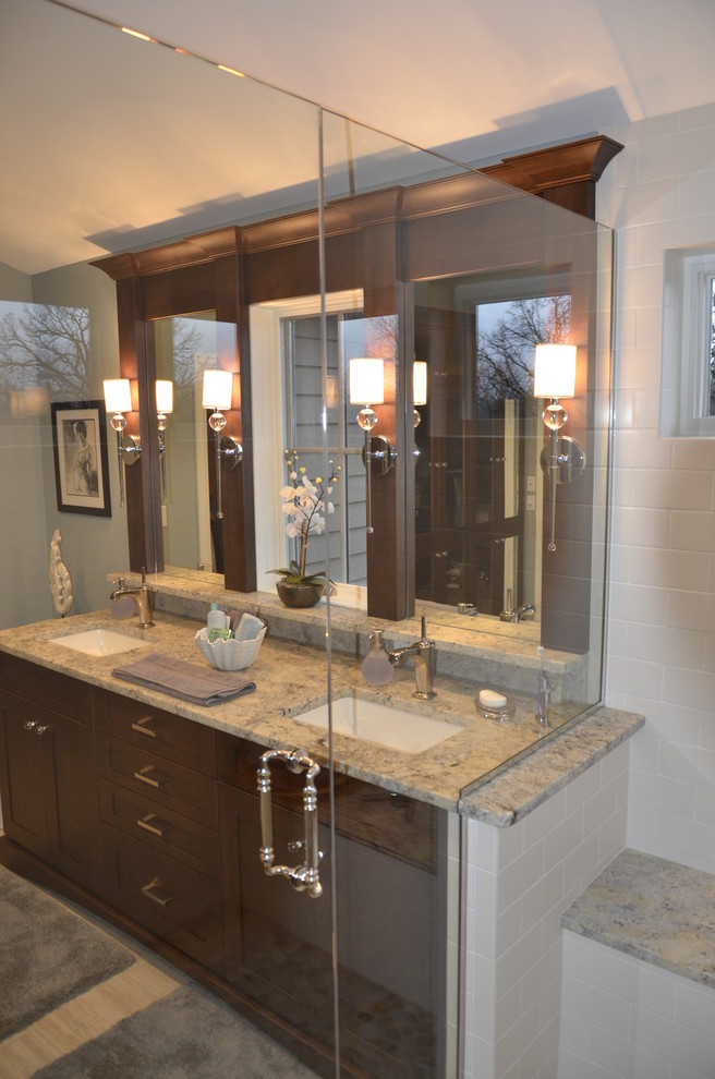 Photo of a transitional master bathroom in Milwaukee with a drop-in sink, flat-panel cabinets, dark wood cabinets, granite benchtops, an alcove shower, porcelain tile, blue walls and porcelain floors.
