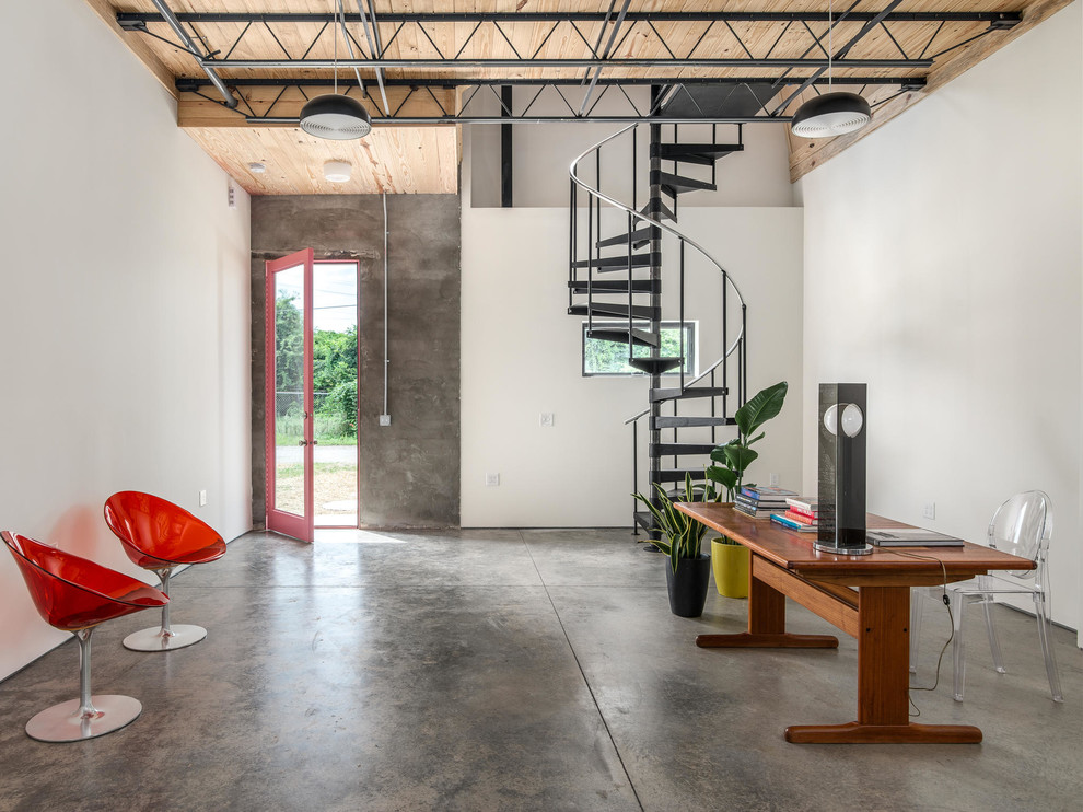 This is an example of a small industrial home studio in Nashville with white walls and concrete floors.