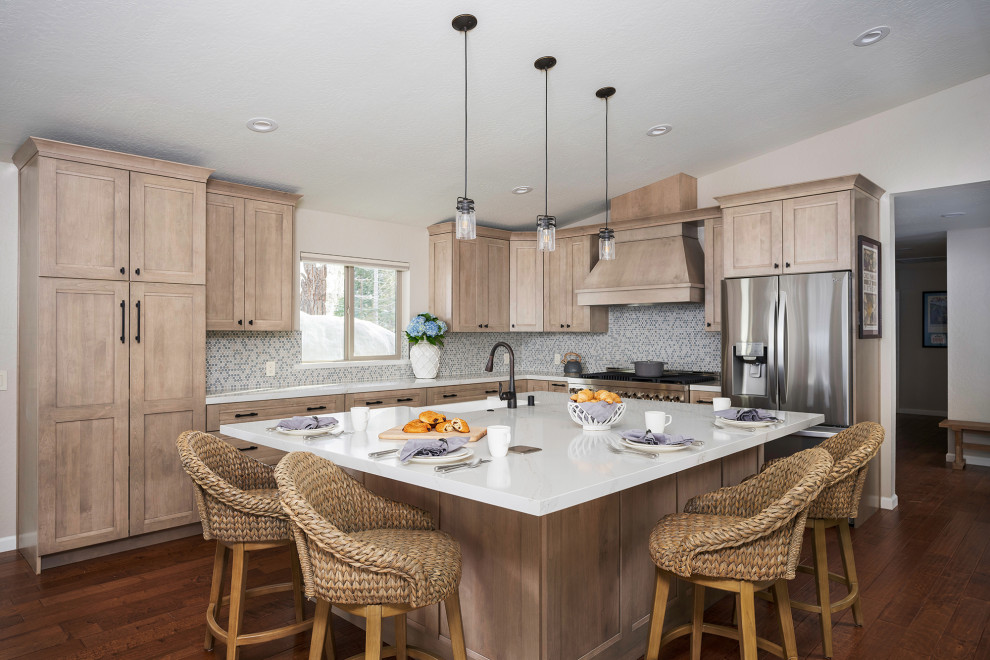 Example of a mid-sized beach style l-shaped medium tone wood floor and brown floor eat-in kitchen design in Other with a single-bowl sink, an island, white countertops, shaker cabinets, light wood cabinets, quartz countertops, blue backsplash, glass sheet backsplash and stainless steel appliances
