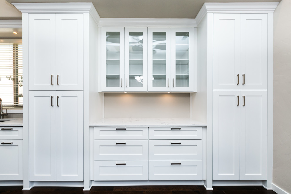 Example of a large transitional l-shaped dark wood floor and brown floor eat-in kitchen design in Albuquerque with a farmhouse sink, shaker cabinets, white cabinets, quartz countertops, gray backsplash, subway tile backsplash, stainless steel appliances and an island