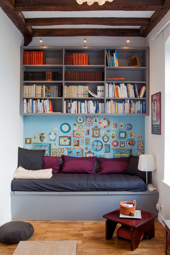 Small eclectic enclosed family room in Angers with a library, medium hardwood floors, no fireplace, no tv and multi-coloured walls.