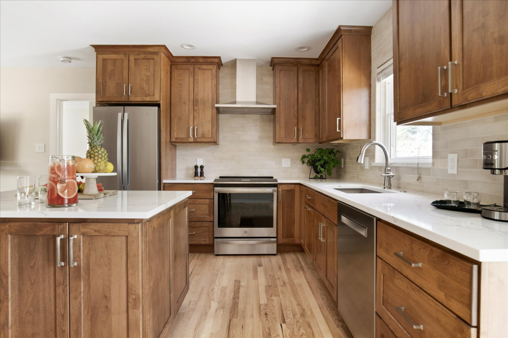 Inspiration for a small transitional l-shaped light wood floor and brown floor eat-in kitchen remodel in Denver with an undermount sink, shaker cabinets, medium tone wood cabinets, beige backsplash, stainless steel appliances, an island and white countertops