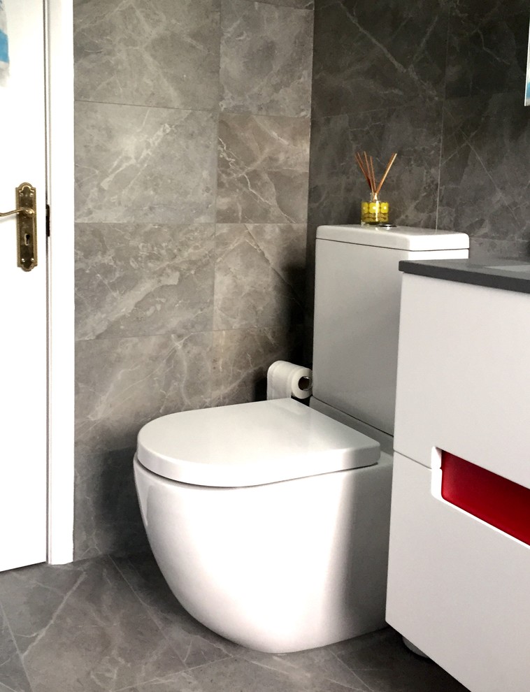 Design ideas for a small contemporary 3/4 bathroom in London with a wall-mount sink, glass-front cabinets, white cabinets, marble benchtops, an open shower, a one-piece toilet, gray tile, porcelain tile, multi-coloured walls and marble floors.