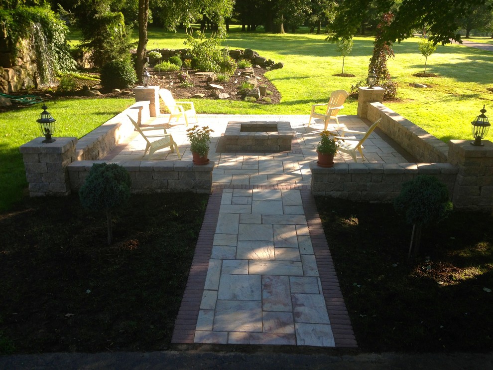 Photo of a mid-sized arts and crafts backyard patio in Cleveland with a fire feature, stamped concrete and no cover.