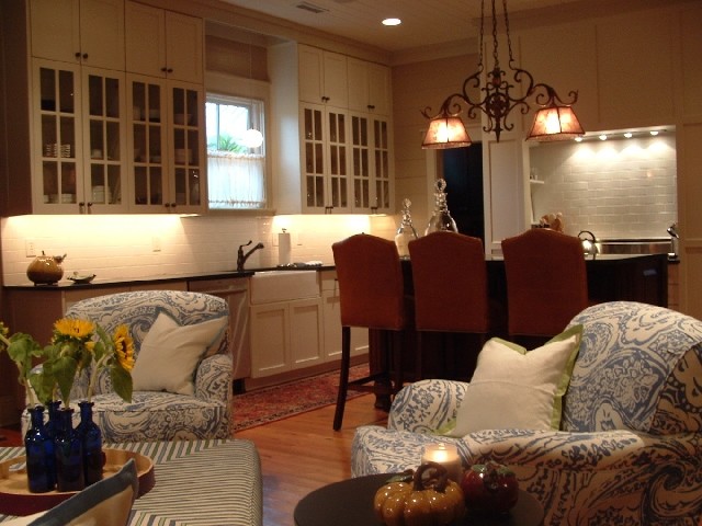 Example of a large transitional l-shaped medium tone wood floor open concept kitchen design with a farmhouse sink, granite countertops, white backsplash, ceramic backsplash and an island