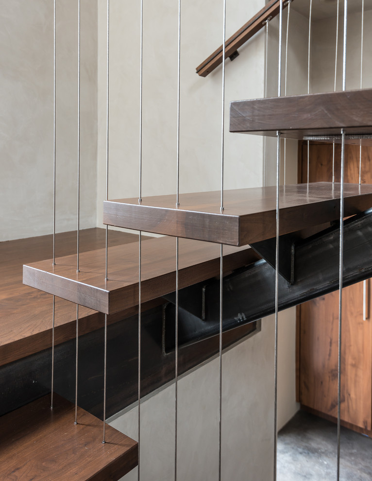 Medium sized contemporary wood floating staircase in Other with wood risers.