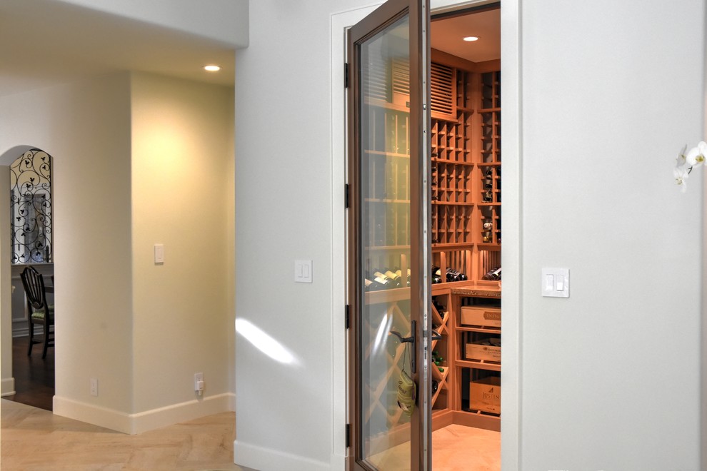 Photo of a mid-sized contemporary wine cellar in Orange County with ceramic floors, display racks and beige floor.