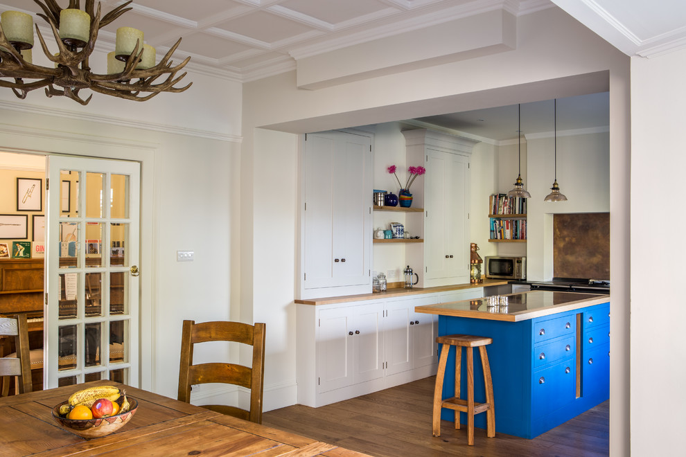 Photo of a large rustic u-shaped kitchen/diner in Other with shaker cabinets, grey cabinets, granite worktops, black appliances, an island, a submerged sink, metallic splashback, metal splashback and light hardwood flooring.
