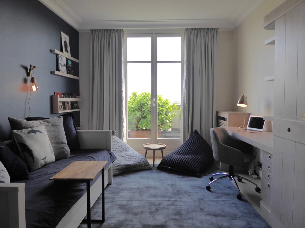 This is an example of a small modern kids' room for boys in Paris with blue walls and light hardwood floors.
