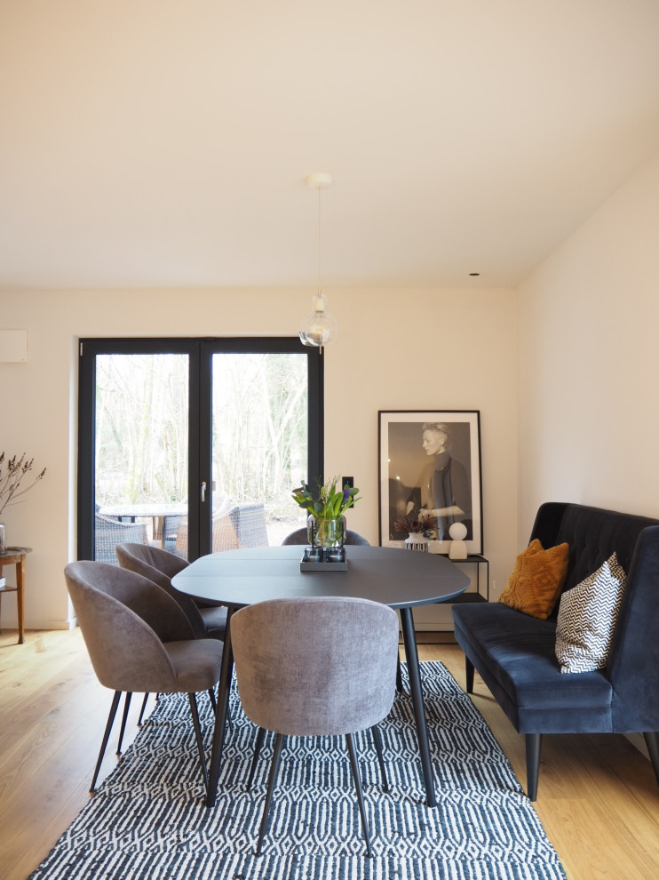 Inspiration pour une petite salle à manger ouverte sur le salon minimaliste avec un mur blanc, un sol en bois brun et un sol marron.