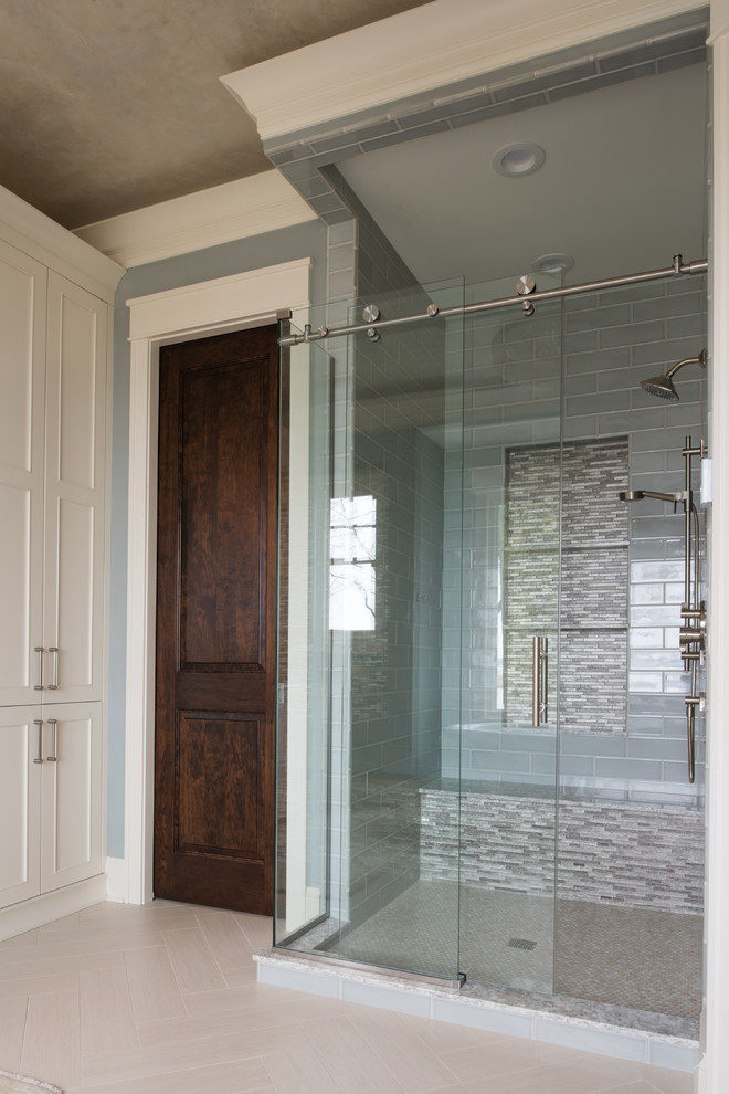 This is an example of a mid-sized traditional master bathroom in Minneapolis with recessed-panel cabinets, white cabinets, a freestanding tub, a corner shower, a one-piece toilet, grey walls, dark hardwood floors, a vessel sink, brown floor and a hinged shower door.