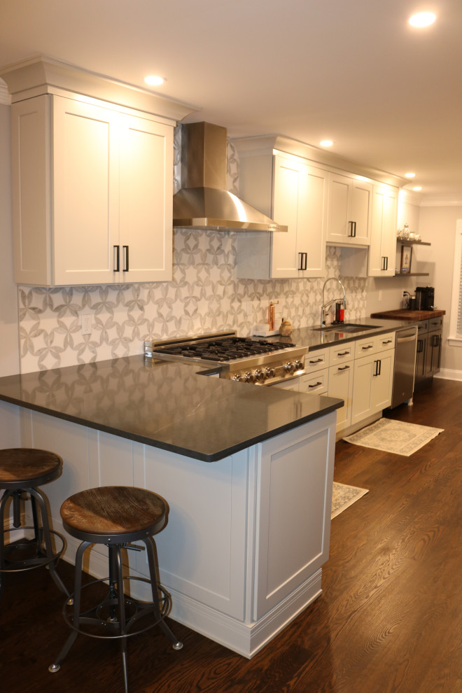 Cette photo montre une cuisine chic de taille moyenne avec un placard à porte shaker, un plan de travail en quartz modifié et un plan de travail gris.