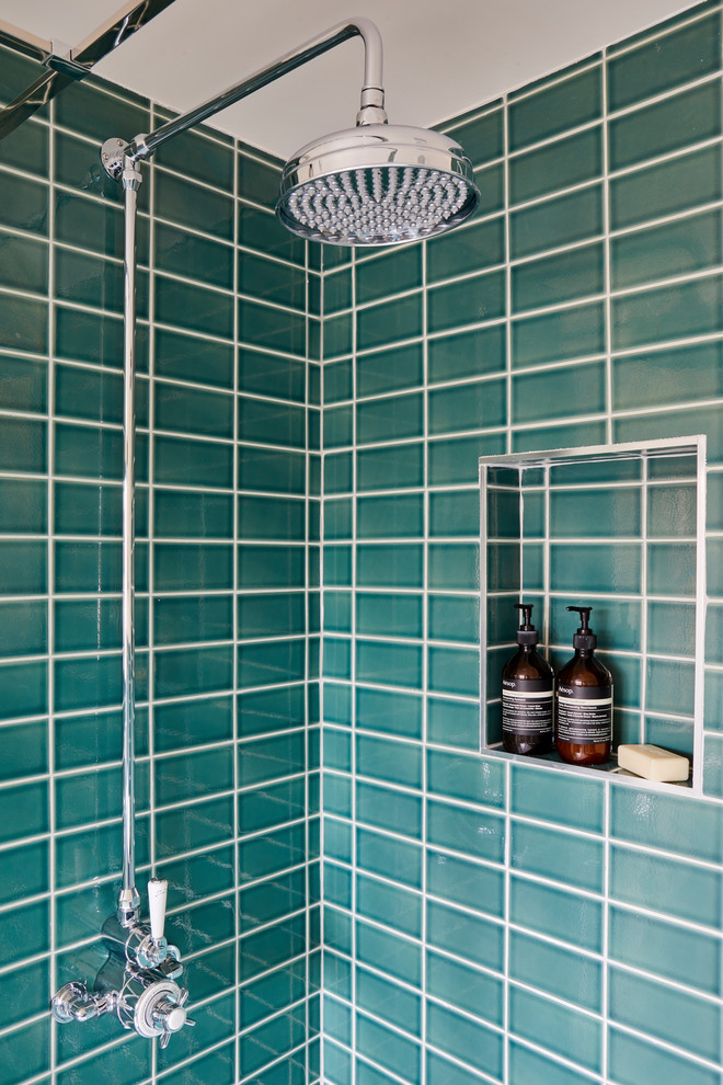 This is an example of a mid-sized traditional master bathroom in London with a freestanding tub, an open shower, a one-piece toilet, green tile, ceramic tile, white walls, ceramic floors, a pedestal sink, grey floor and a hinged shower door.