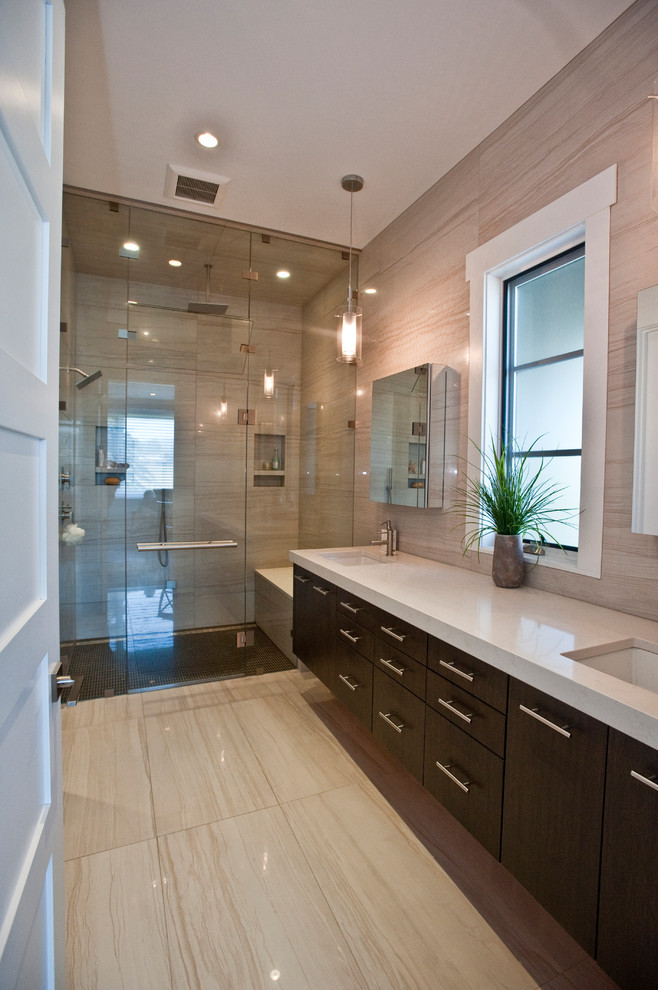 This is an example of a large contemporary master bathroom in Other with flat-panel cabinets, a double shower, a one-piece toilet, an undermount sink, engineered quartz benchtops, brown cabinets, beige tile, marble, beige walls, marble floors, beige floor and a hinged shower door.