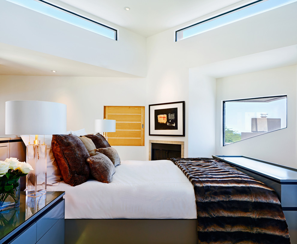 Contemporary master bedroom in Phoenix with white walls and a corner fireplace.