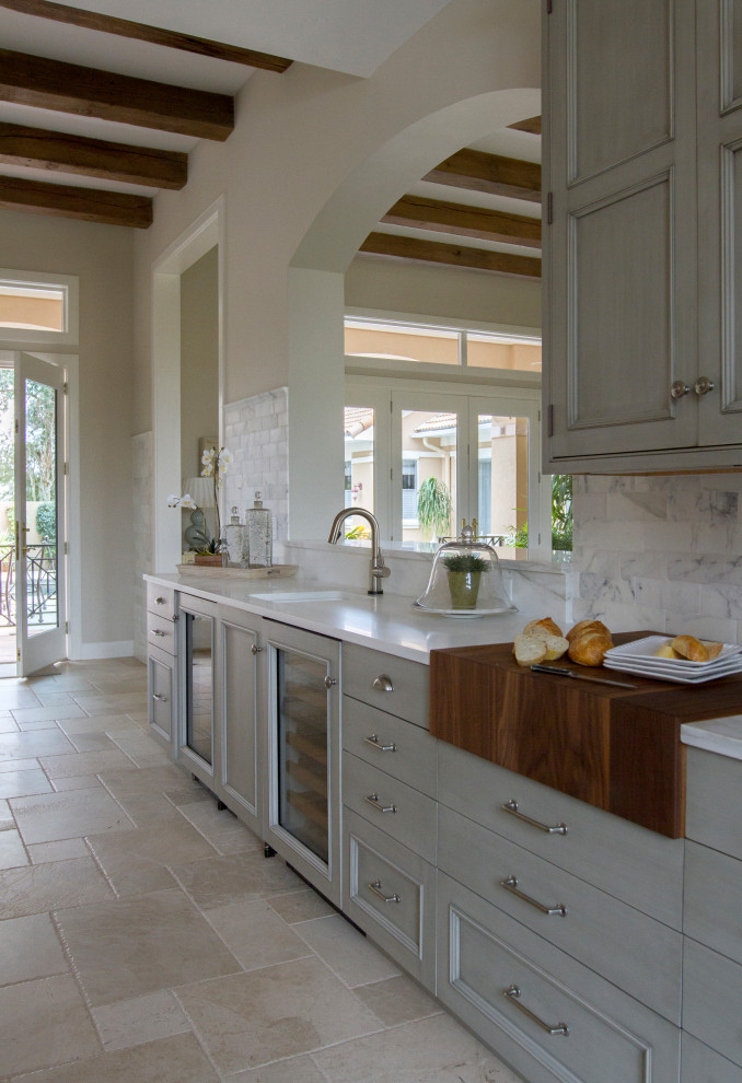 Inspiration for a large mediterranean u-shaped eat-in kitchen in Other with an undermount sink, beaded inset cabinets, grey cabinets, white splashback, stainless steel appliances, porcelain floors, with island, beige floor and white benchtop.