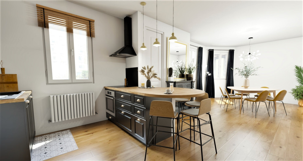 Industriell inredning av ett mellanstort kök, med en undermonterad diskho, svarta skåp, träbänkskiva, svart stänkskydd, stänkskydd i marmor, ljust trägolv och en köksö