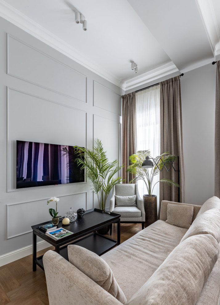 Inspiration pour un salon gris et blanc traditionnel de taille moyenne avec un mur gris, un sol en bois brun, un téléviseur fixé au mur, un sol marron et poutres apparentes.