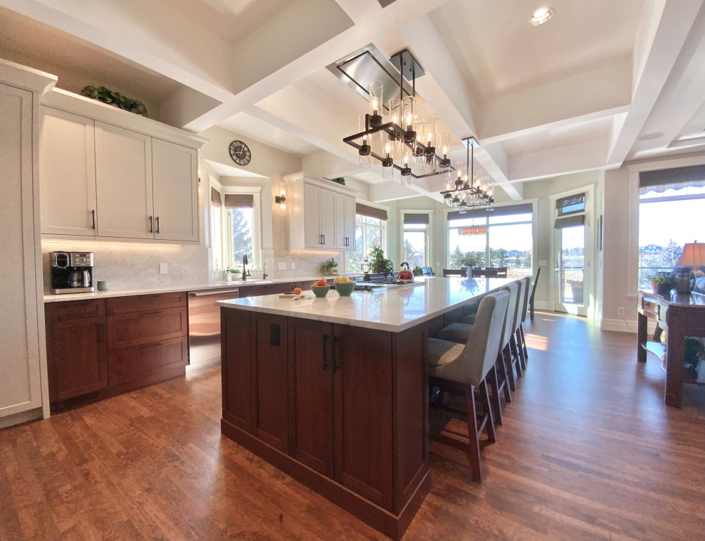 Inspiration for a large transitional single-wall dark wood floor, brown floor and coffered ceiling eat-in kitchen remodel in Calgary with an undermount sink, shaker cabinets, white cabinets, quartzite countertops, white backsplash, an island and white countertops