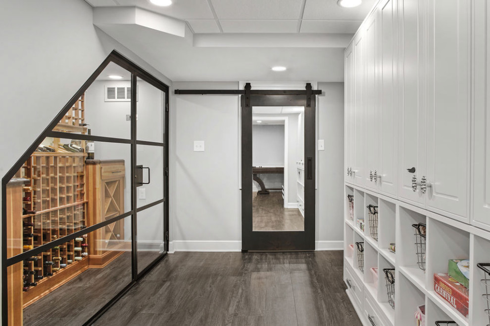 Photo of a small contemporary wine cellar in Columbus with vinyl floors, storage racks and grey floor.