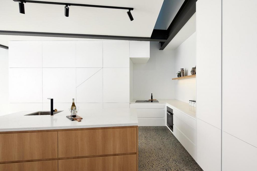 Design ideas for a small contemporary l-shaped open plan kitchen in Sydney with a farmhouse sink, white cabinets, marble benchtops, white splashback, ceramic splashback, black appliances, concrete floors, with island, grey floor and white benchtop.