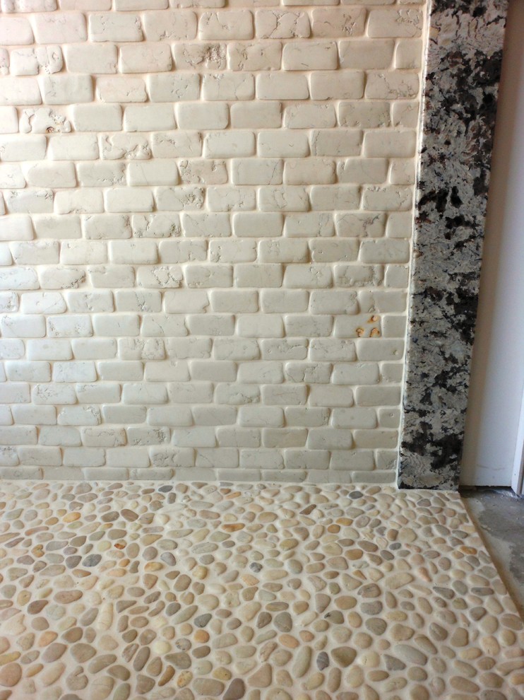 Example of a large mountain style master beige tile and stone tile pebble tile floor walk-in shower design with granite countertops