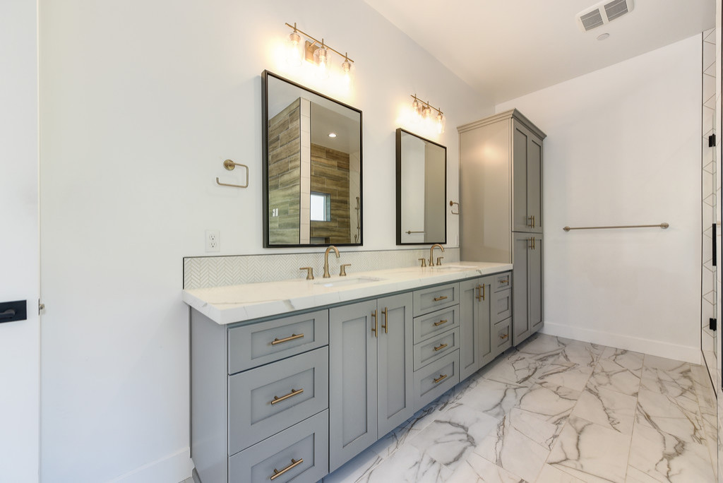 Large trendy master white tile and glass sheet ceramic tile, multicolored floor and single-sink bathroom photo in Sacramento with gray cabinets, a one-piece toilet, white walls, a drop-in sink, quartz