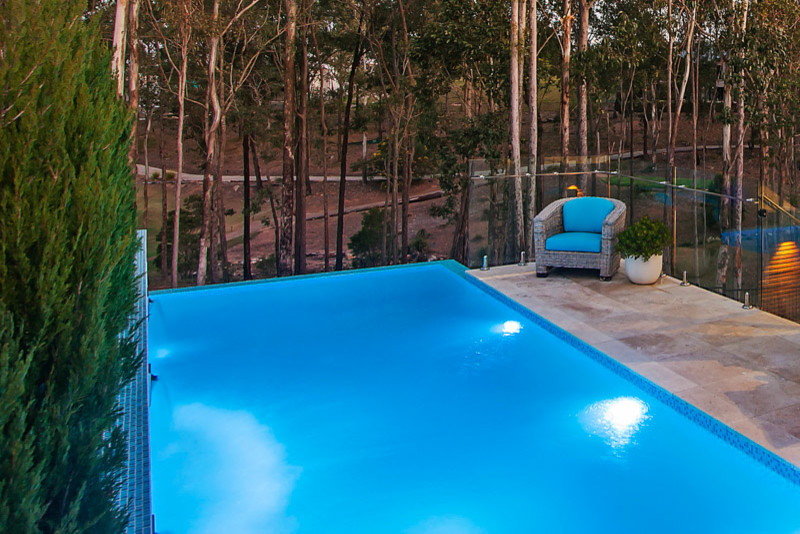 Mid-sized contemporary backyard rectangular aboveground pool in Brisbane with a water feature and tile.