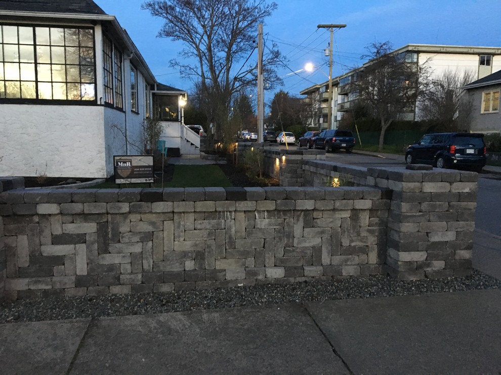 Photo of a huge rustic full sun front yard concrete paver retaining wall landscape.