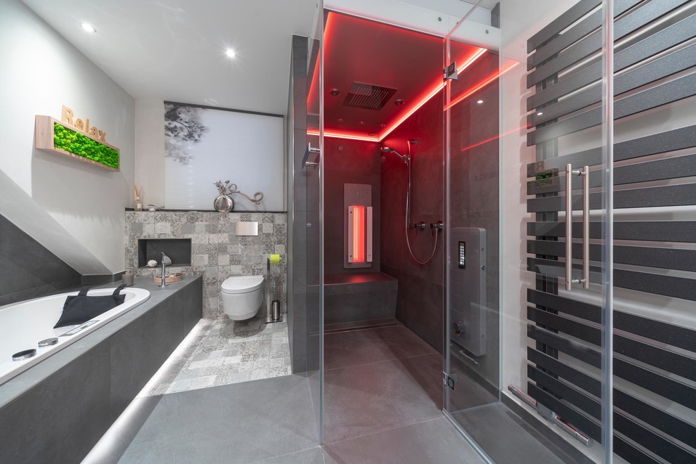 This is an example of a large contemporary bathroom in Stuttgart with light wood cabinets, a hot tub, a curbless shower, a two-piece toilet, gray tile, stone tile, white walls, ceramic floors, with a sauna, a vessel sink, grey floor, a hinged shower door and brown benchtops.