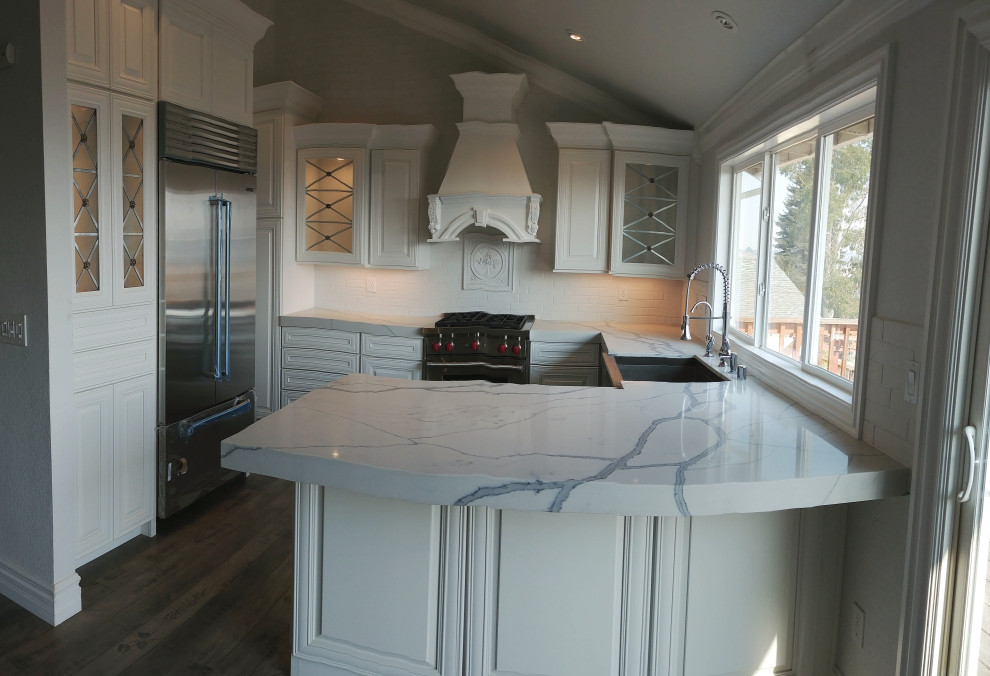 Idéer för att renovera ett mellanstort vit vitt kök, med en rustik diskho, luckor med glaspanel, vita skåp, granitbänkskiva, vitt stänkskydd, stänkskydd i keramik, rostfria vitvaror, laminatgolv, en köksö och grått golv