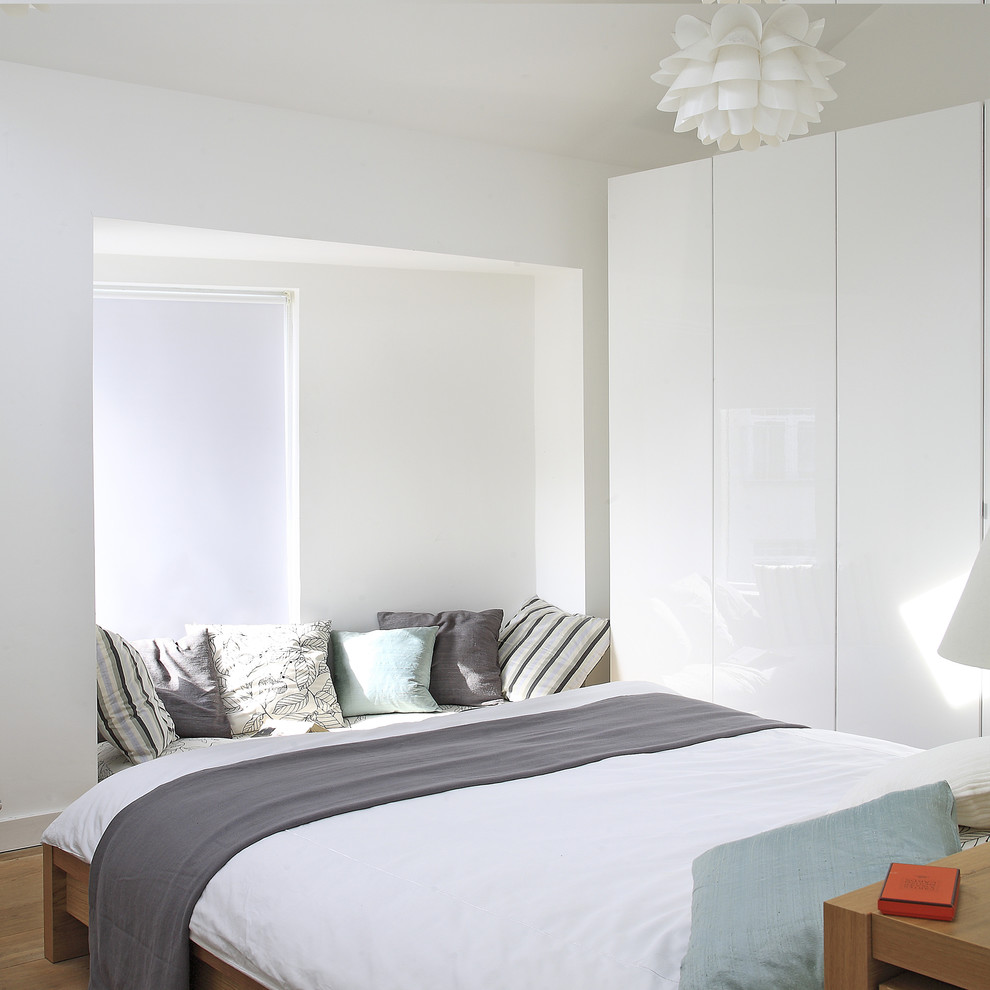 Contemporary master bedroom in Dublin with white walls.