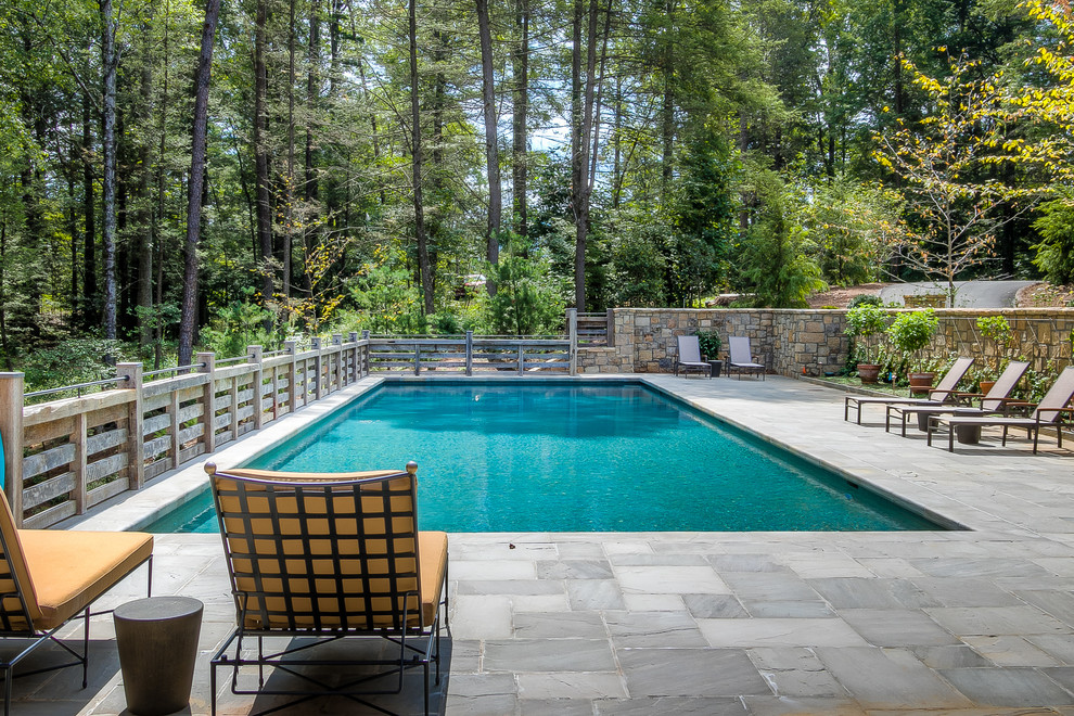Photo of a country rectangular lap pool in Other with natural stone pavers.