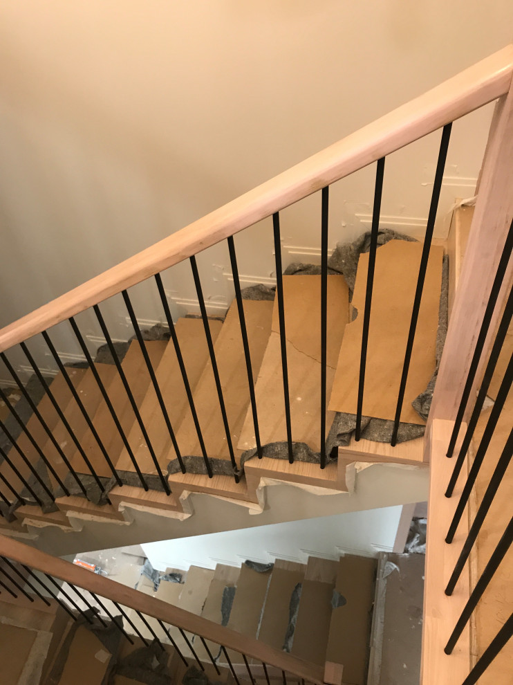 Ejemplo de escalera recta industrial de tamaño medio con escalones de madera, contrahuellas de madera, barandilla de metal y papel pintado