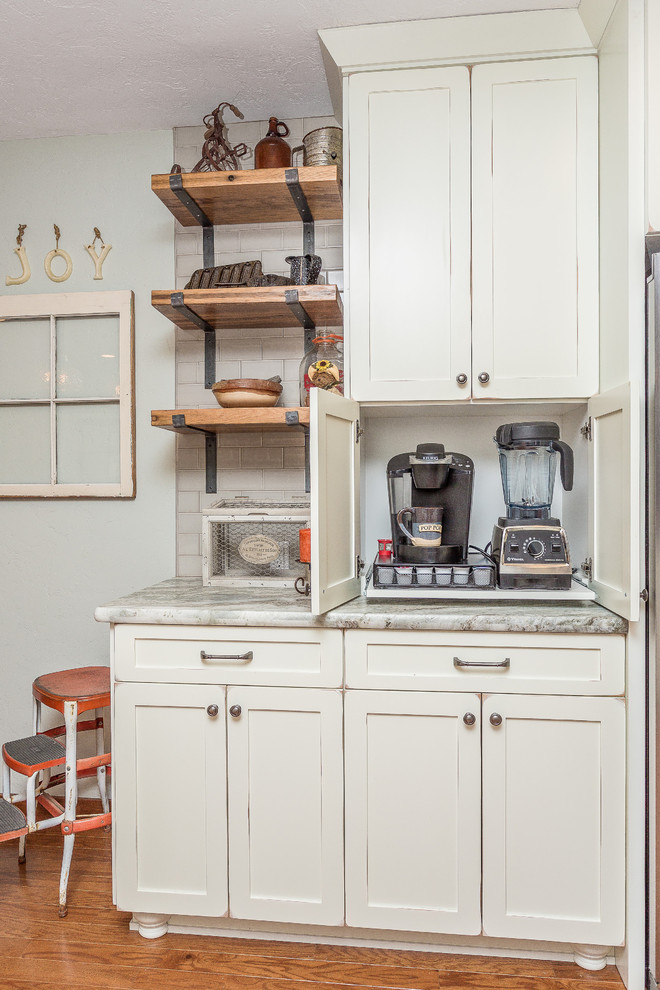 Large transitional l-shaped medium tone wood floor and brown floor open concept kitchen photo in Phoenix with a farmhouse sink, shaker cabinets, white cabinets, quartzite countertops, gray backsplash, porcelain backsplash, stainless steel appliances and no island