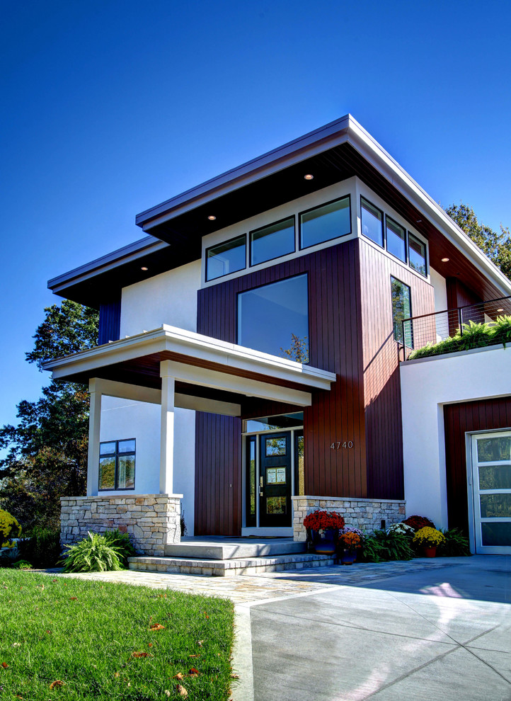 Large contemporary two-storey white exterior in Grand Rapids with mixed siding and a flat roof.
