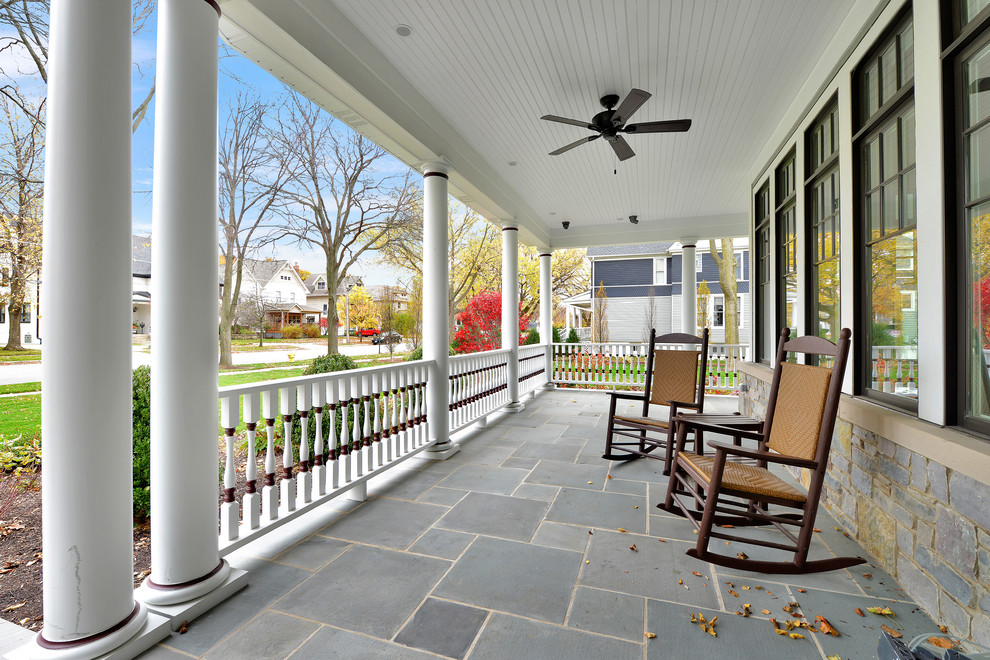 Large traditional front yard verandah in Chicago with a roof extension and tile.