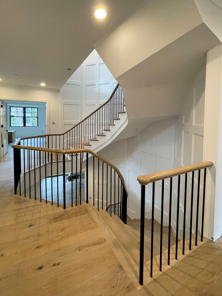 Large classic wood floating mixed railing staircase in DC Metro with painted wood risers and wainscoting.