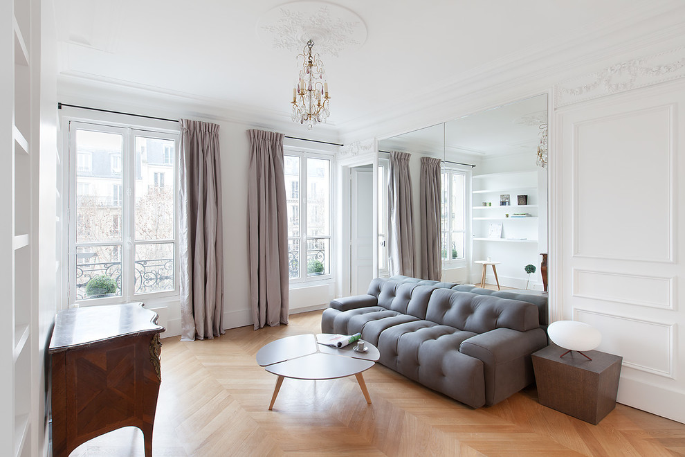 Design ideas for a mid-sized contemporary enclosed living room in Paris with white walls, medium hardwood floors, no fireplace and no tv.
