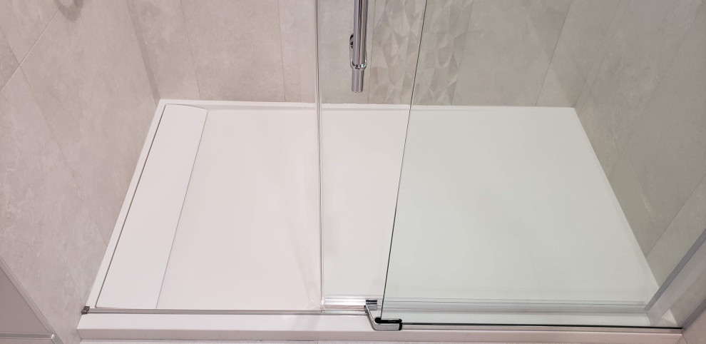 Alcove shower - large transitional porcelain tile, white floor and single-sink alcove shower idea with medium tone wood cabinets, a one-piece toilet, white walls, an integrated sink, quartzite countertops, white countertops, a niche and a floating vanity