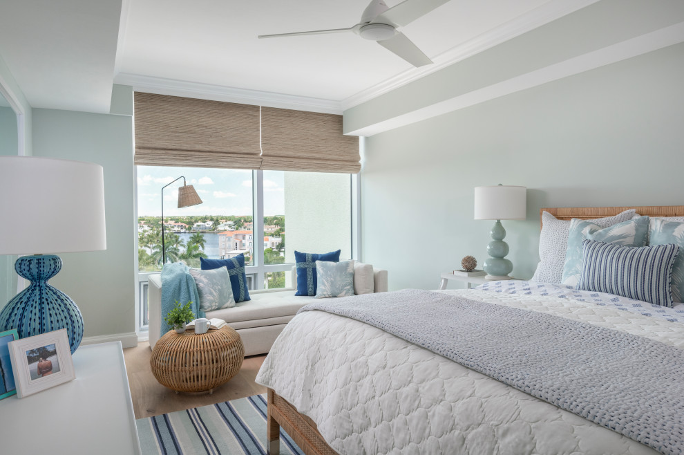 Large beach style guest bedroom in Other with green walls, medium hardwood floors and brown floor.