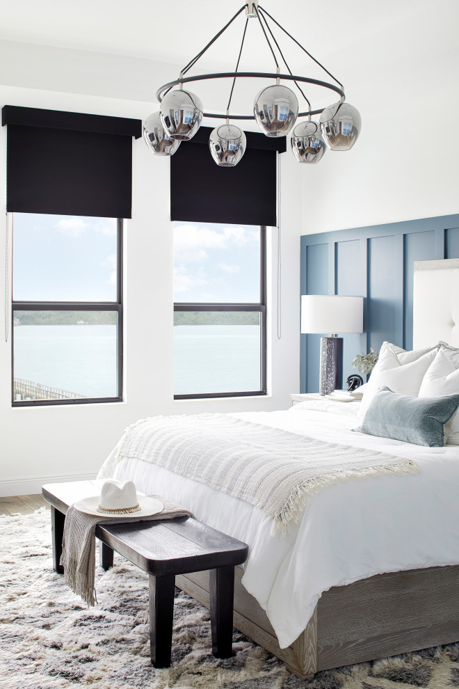 Ejemplo de dormitorio costero con paredes azules y panelado